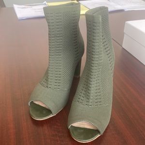 Stretchy olive green peep toe booties with stacked heel.